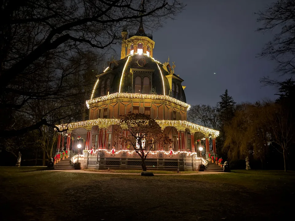 An octagonal-shaped mansion lit up at night.