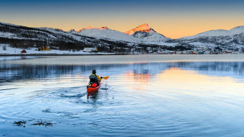 Kayak with snow-covered mountains at sunset