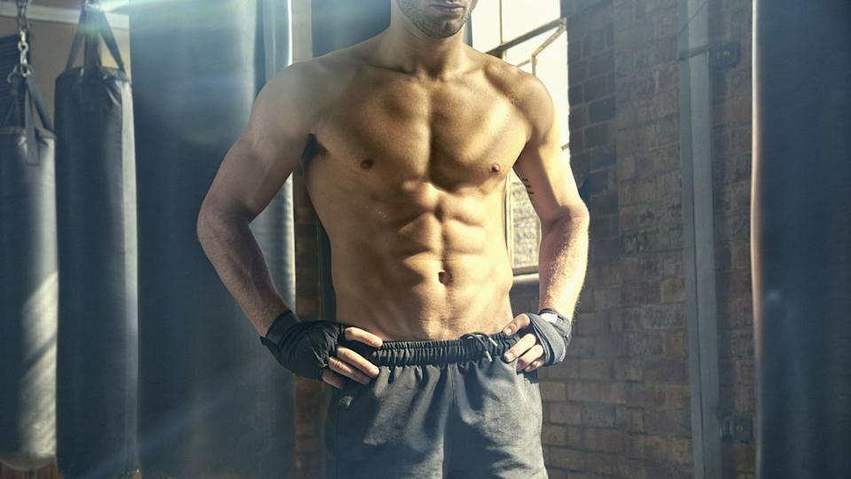  Shirtless man with defined pectoral and abs muscles. 