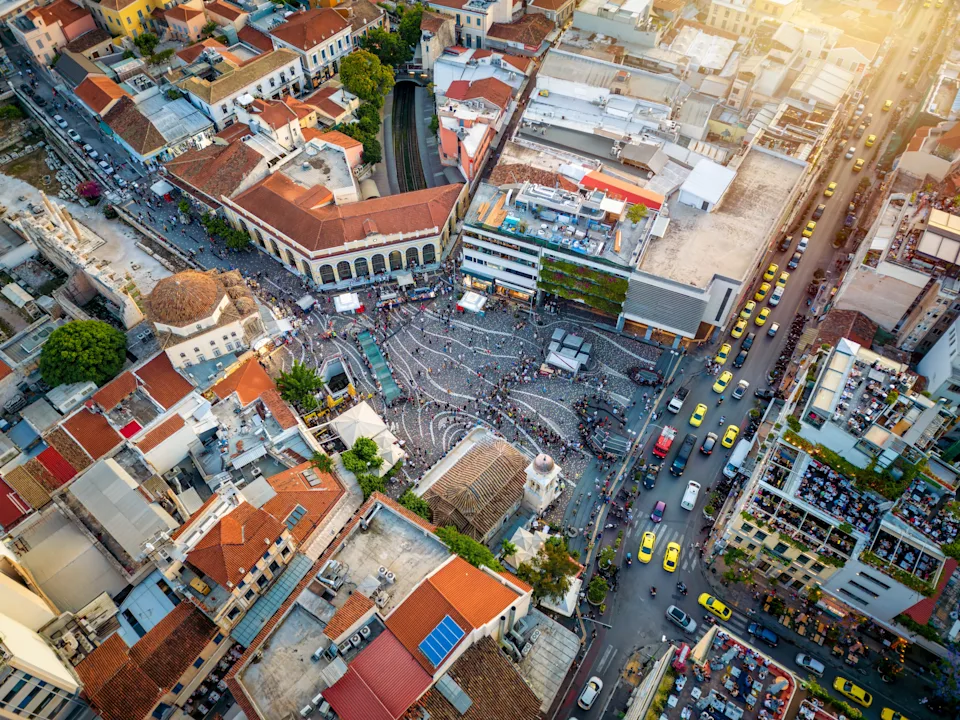 Aerial view of a bustling city square with surrounding buildings and streets busy with traffic and people