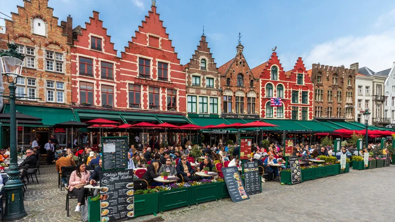Ornate facades line a busy street in Bruges, Belgium