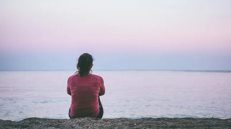 A lone woman sitting at the beach