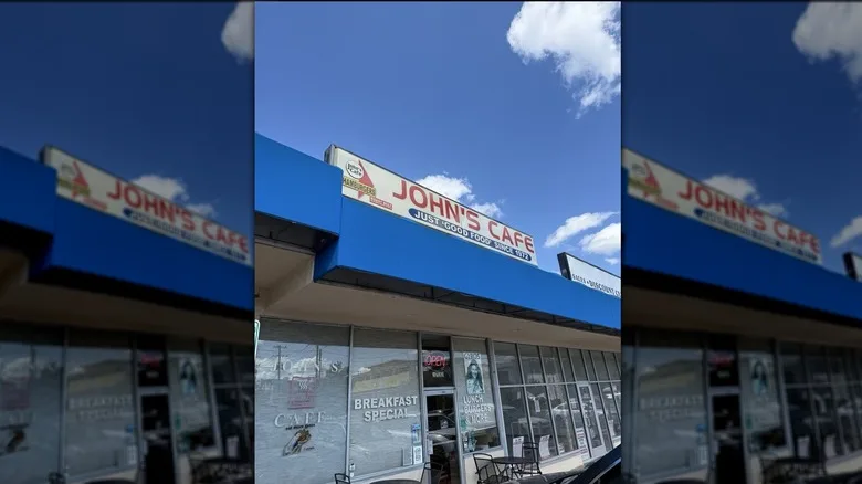 Exterior of John's Cafe with a cloudy blue sky in the background