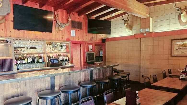 Jocko's interior, deer heads on the wall, a bar with drinks behind it, small tables and chairs