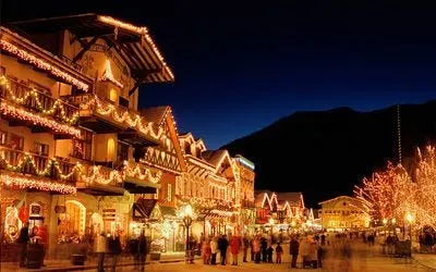 a group of people walking around during christmas light displays in leavenworth washington for christmas lighting