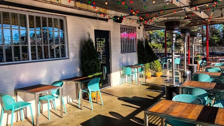The outdoor patio at Hummingbird with colorful string lights and the pink neon sign