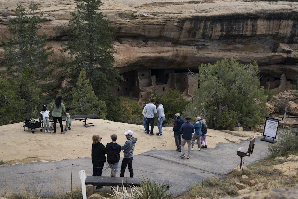 MANCOS, COLORADO - OCTOBER 4: Visitors view the cliff dwellings next to trail closed signs inside Mesa Verde National Park during the government shutdown on October 4, 2025 in Mancos, Colorado. National Park Trails and open-air sites remain open, while most staffed facilities closed due to the government shut down early last Wednesday after Congress failed to reach a funding deal.