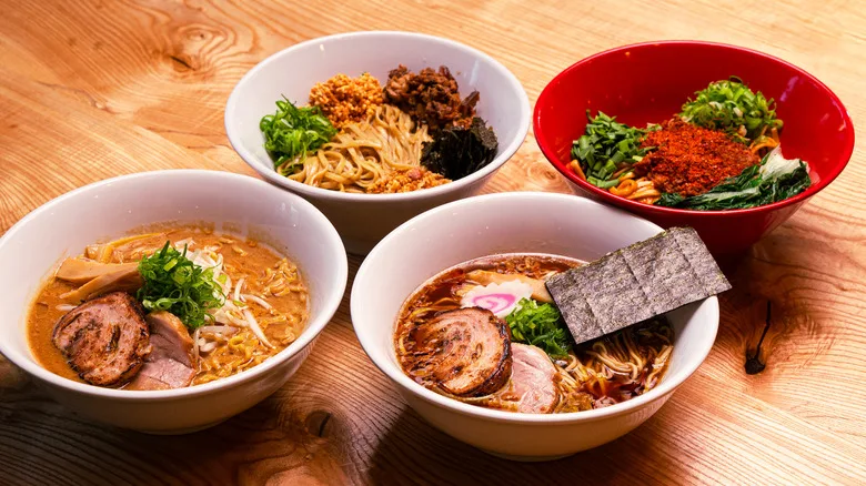 The four main ramen dishes available at Akahoshi Ramen on a wooden table.
