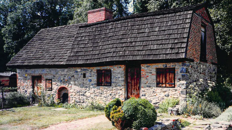 Caleb Pusey House in Upland, with a yard leading up to the building with stone walls and a black shingle roof