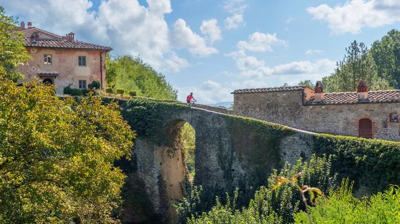 Woman cycling in a village near Laterina, Province Arezzo in Tuscany, Italy