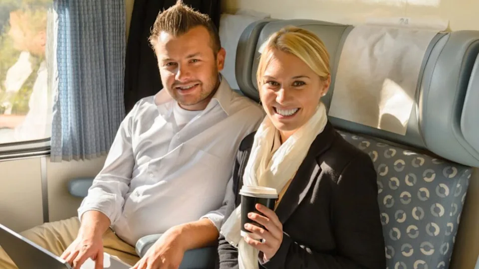 Woman and man sitting in train smiling