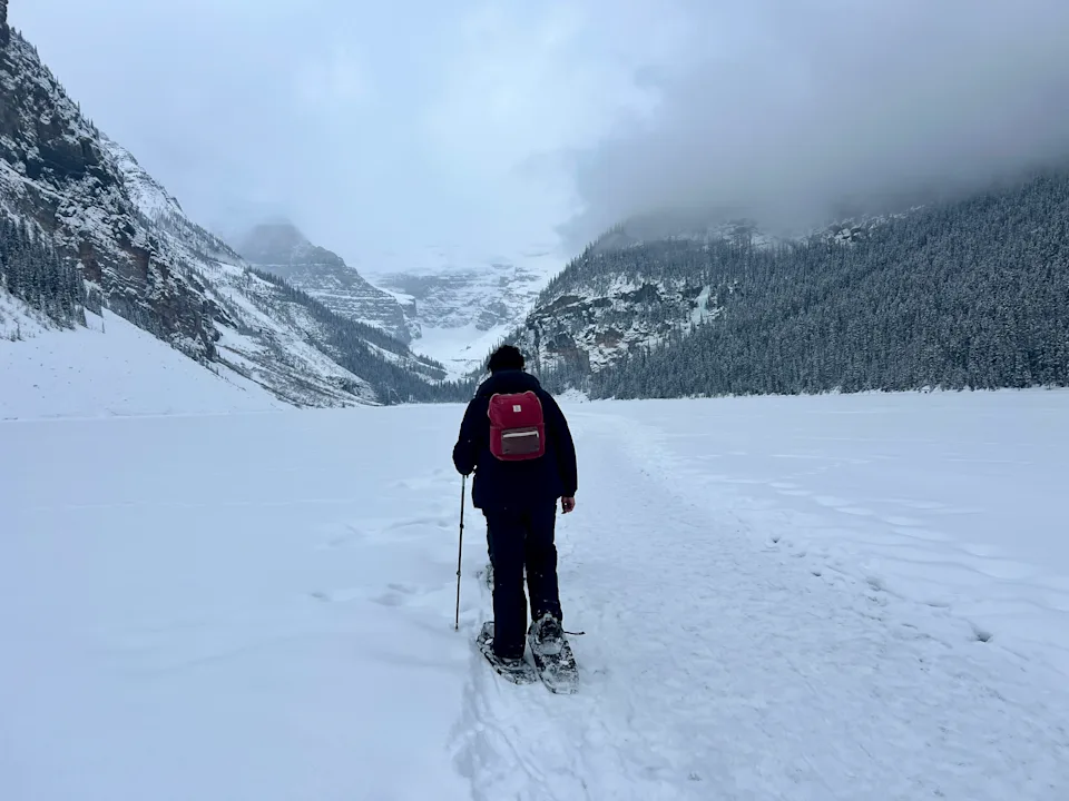 A man snowshoes on Lake Louise in Banff in winter.