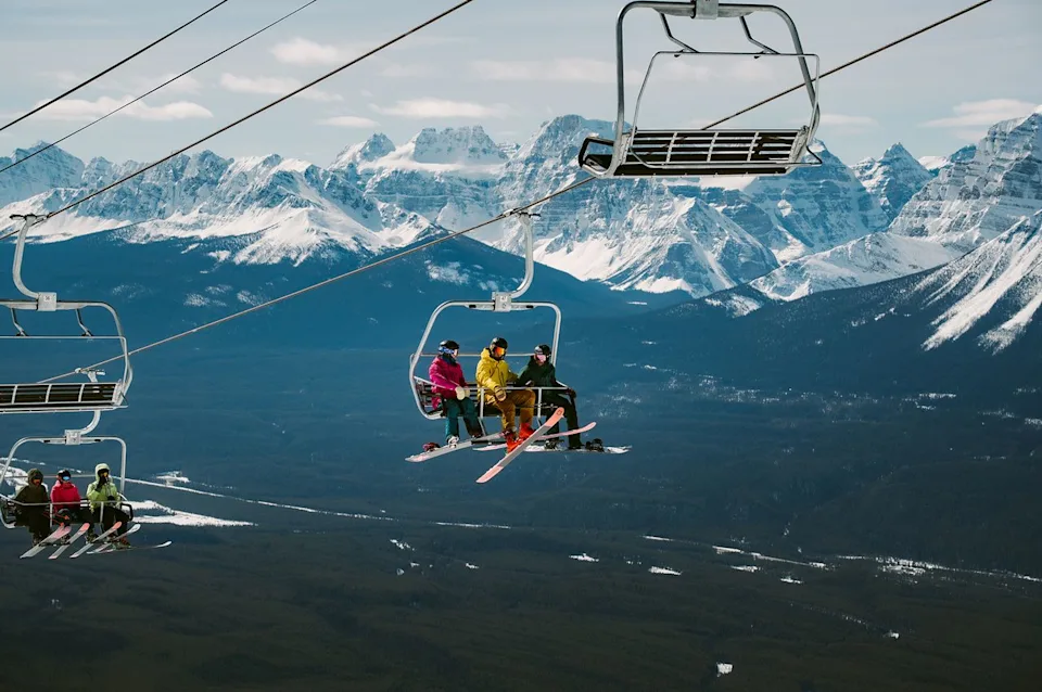 Sam Louise Skiers and snowboarders on the lift at the Lake Louise Ski Resort.