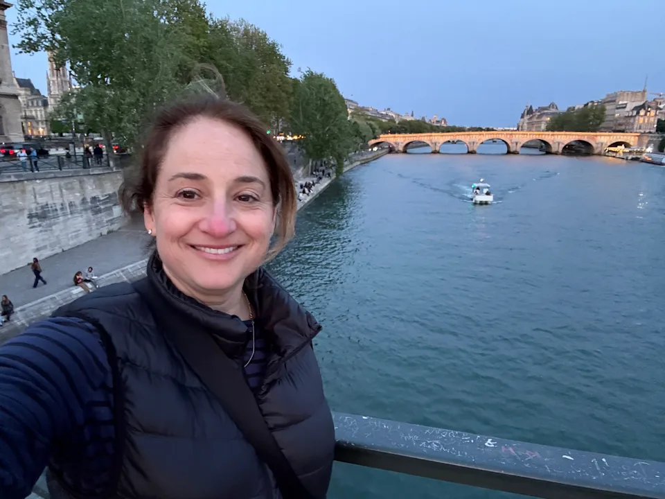 Jaime poses in front of a river in Paris.