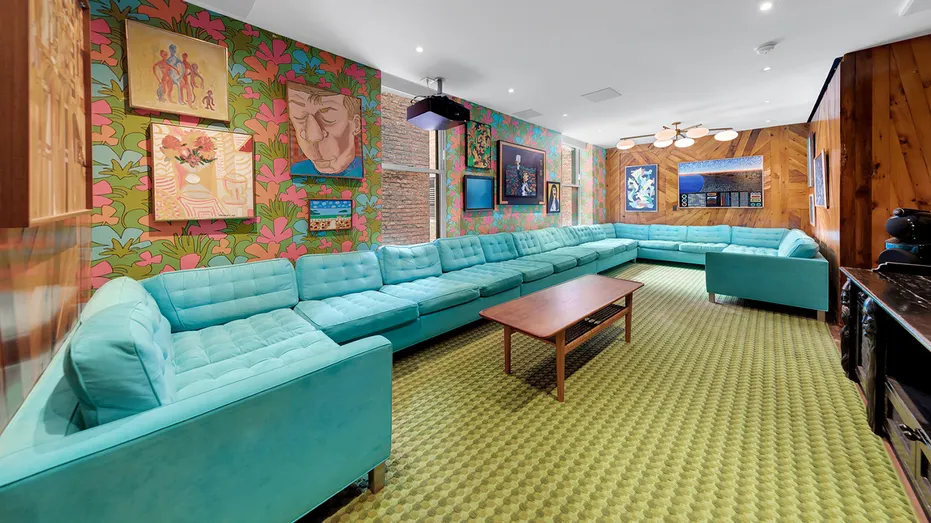 The home features 70s-themed decor, including floral wallpaper and a large blue couch.