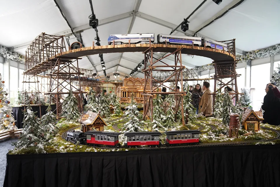 Zhang Fengguo/Xinhua via Getty Images - PHOTO: Visitors watch a model train during a preview of the Holiday Train Show at New York Botanical Garden in New York City, Nov. 11, 2025.