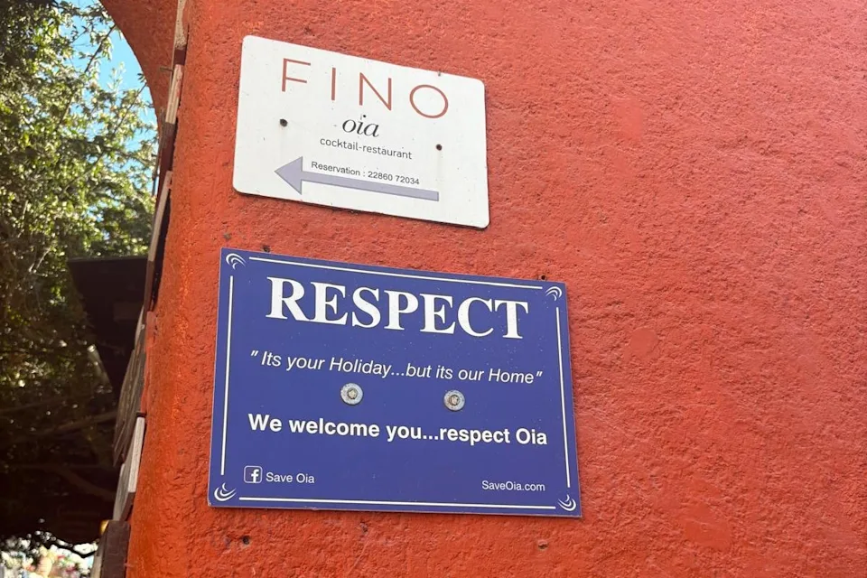 A sign up in Santorini asking visitors to respect Oia (Amelia Neath)