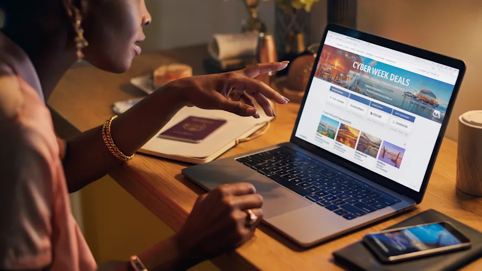 an image of a black woman browsing cyber monday travel deals on her laptop