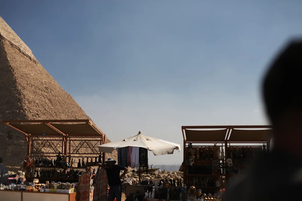 Market and gift shop atThe pyramid of Chephren is one of the Ancient Egyptian Pyramids of Giza that still has cladding at the top. Famous travel destination, sunny day in a touristic area in Cairo, Egypt. Geometric shape, contrast light and shadow in the desert.