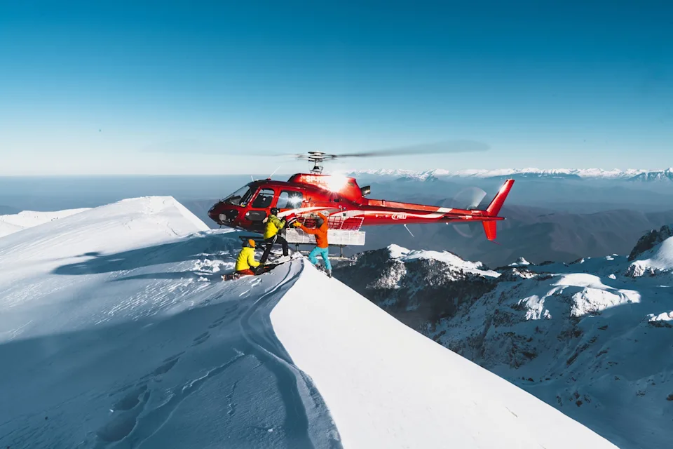 A helicopter putting skiers on the mountain.