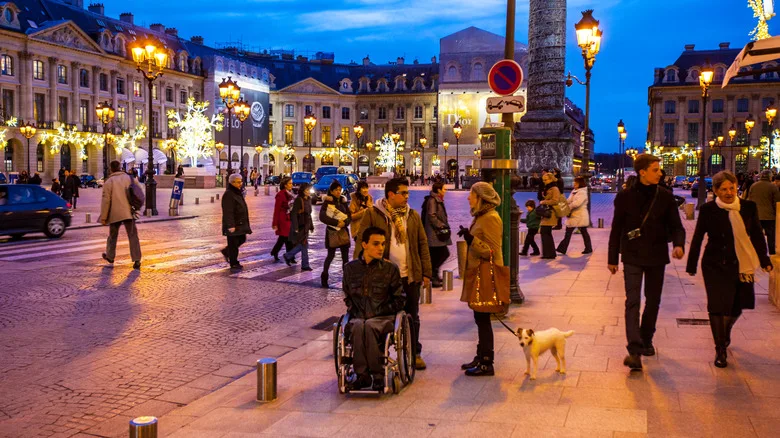 Man in a wheelchair in city square in Paris, France