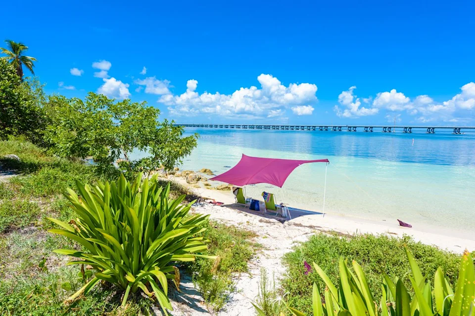 Simon Dannhauer/Adobe Stock A pink canopy covers two beach chairs on Bahia Honda State Park.