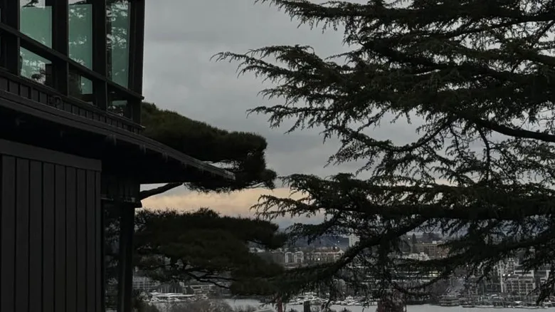 A side view of Canlis Restaurant with the Seattle skyline in the background.