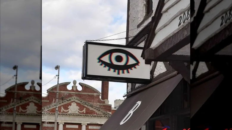 Exterior shot of Bond Street Bar with sign with awnings and sign that has bar's eyeball logo