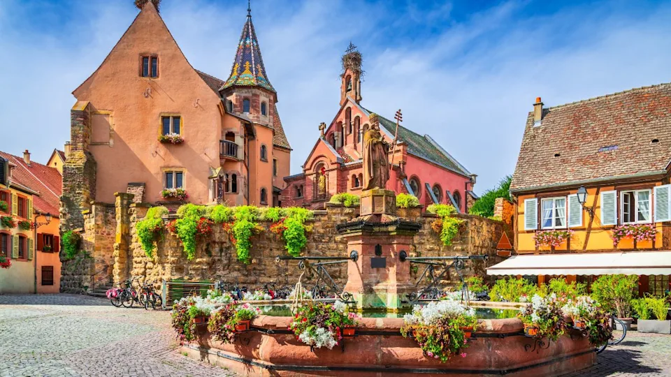 Eguisheim, France. Place du Chateau Saint Leon in picturesque village with colorful half-timbered houses and flower-filled balconies, France.