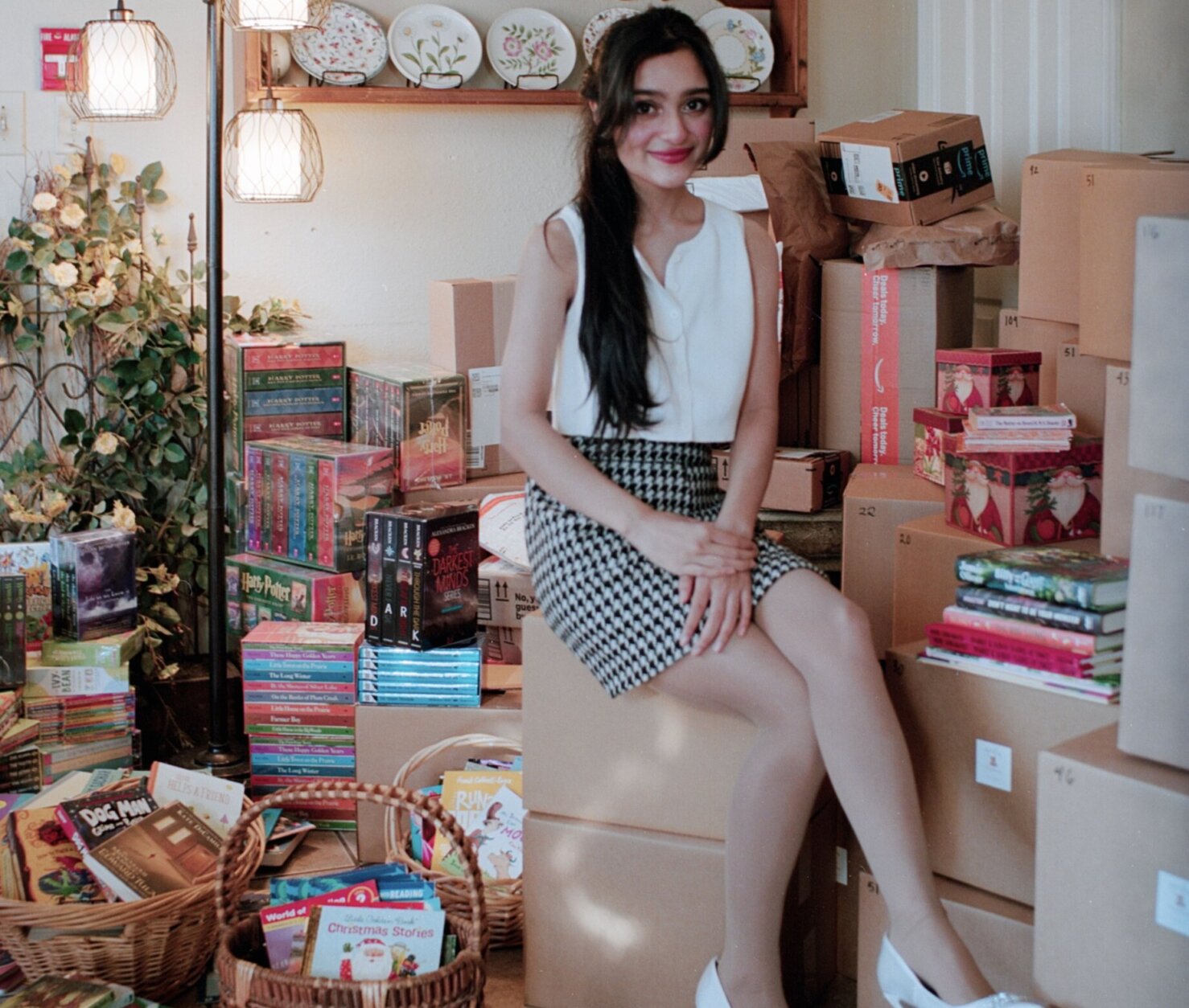 Emily Bhatnagar sits among books for donation