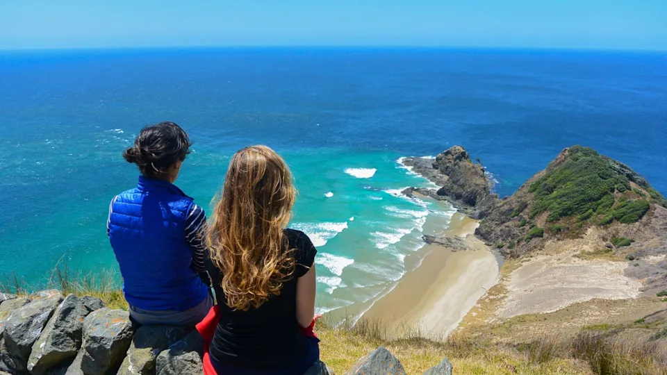 Two women looking at the view from Cape Reinga, north edge of New Zealand.