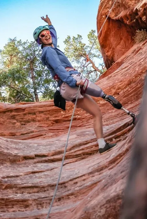 Brenna Huckaby rock climbing during a team bonding retreat.
