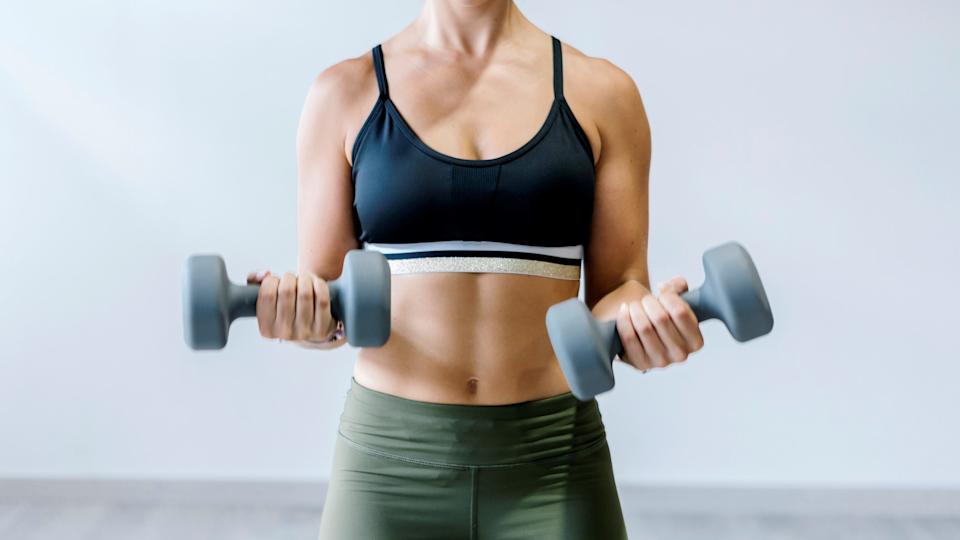 this woman holding a dumbbell workout