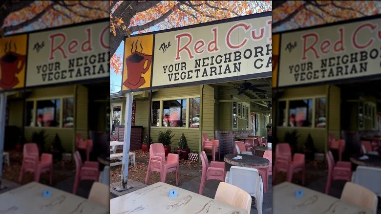 Patio of The Red Cup with wooden tables and red chairs