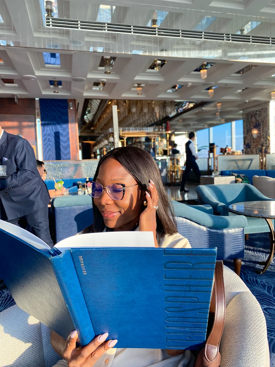I sat inside Atmosphere Restaurant reading the blue menu while wearing stylish sunglasses and enjoying the city views.