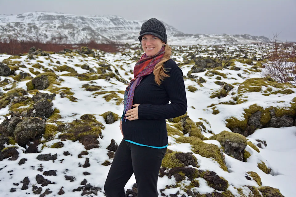 Pregnant woman posing in Iceland with snow in the background.