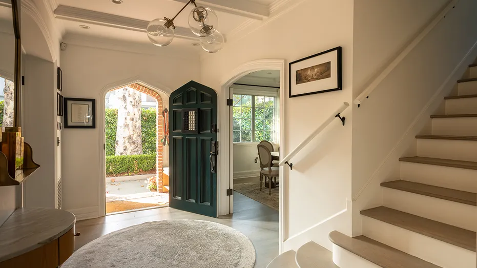 The entryway features a unique light fixture and access to the upper level.