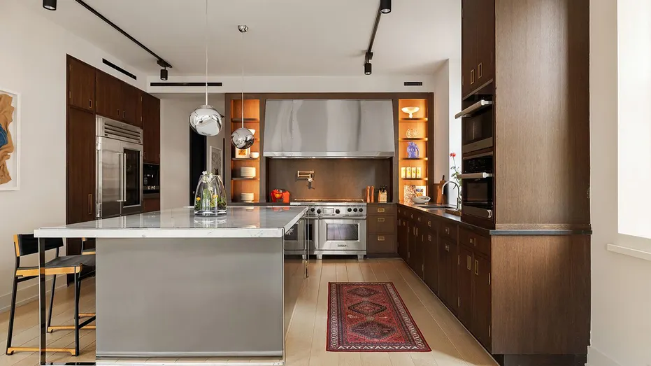 The kitchen features a large center island and wooden cabinetry.