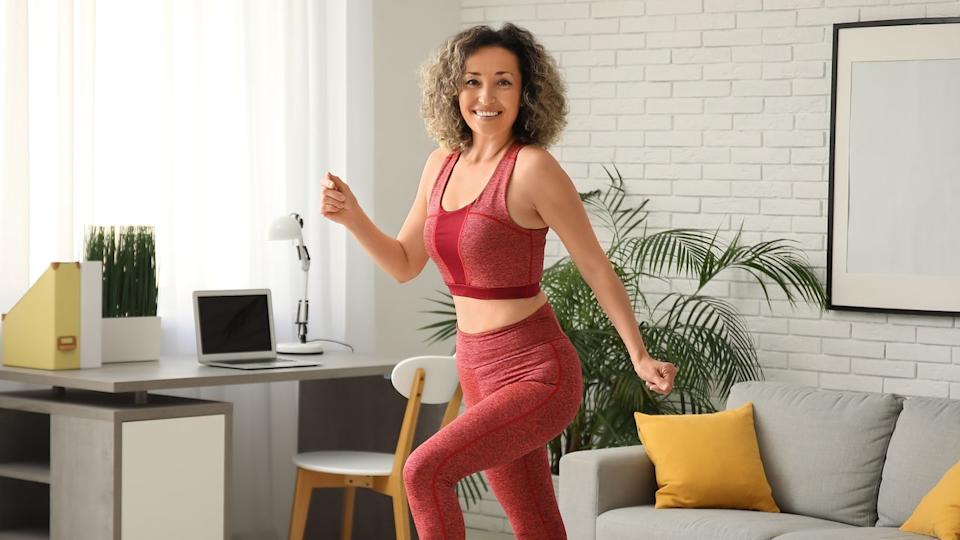  A woman doing a walking workout at home. 