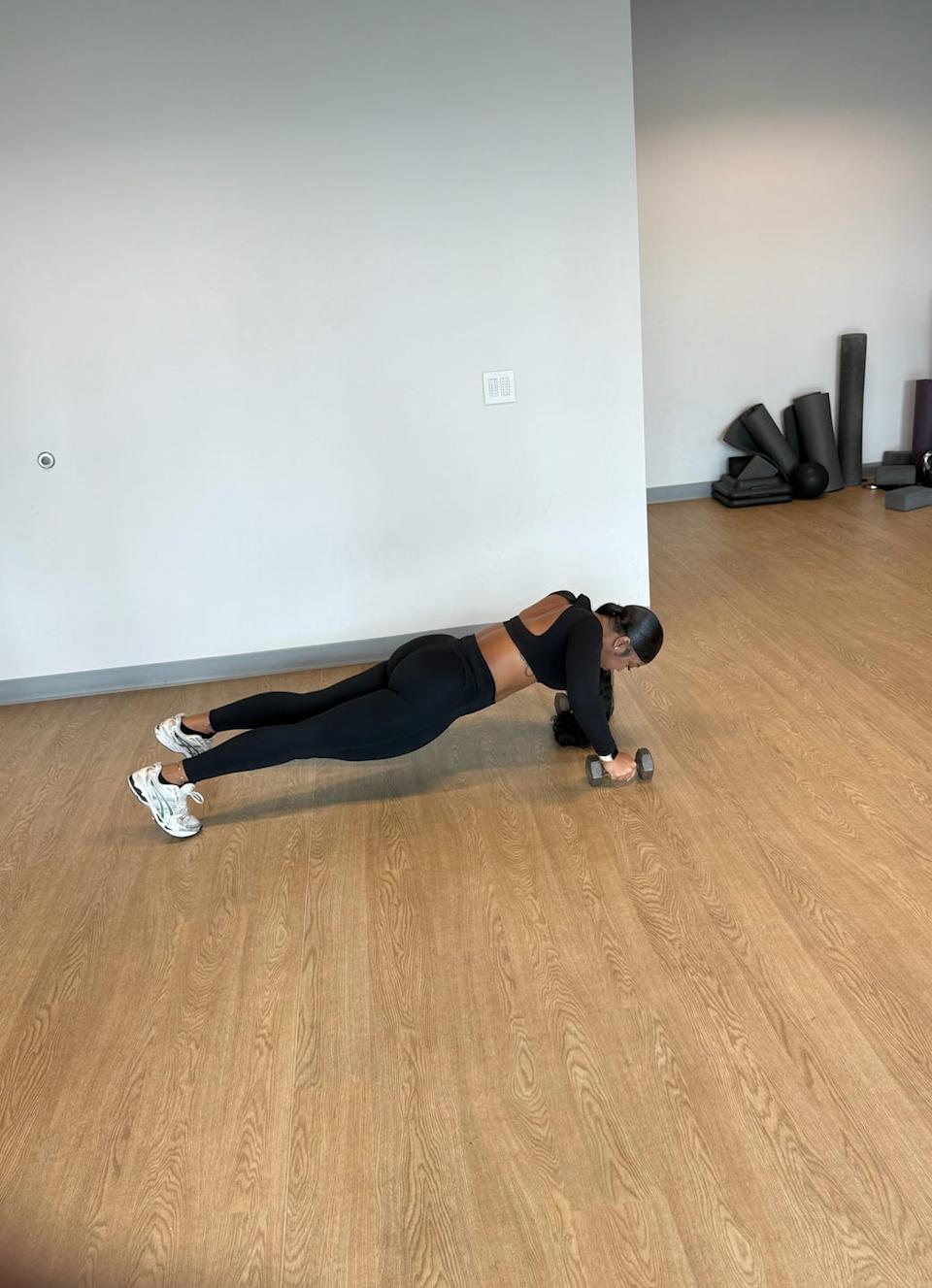 person performing a workout using a dumbbell in a fitness studio