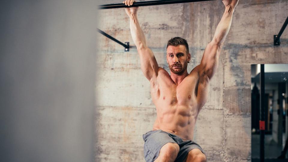 A man doing a hanging knee raise.