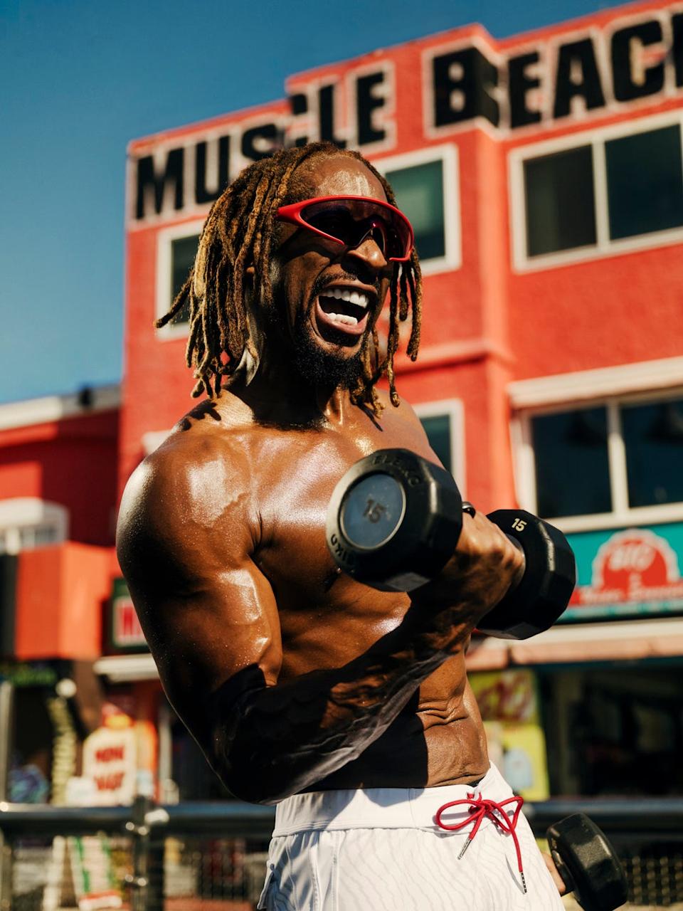 a muscular individual exercising with dumbbells in an outdoor gym