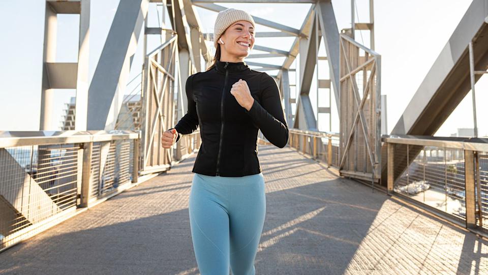  A woman running across a bridge. 