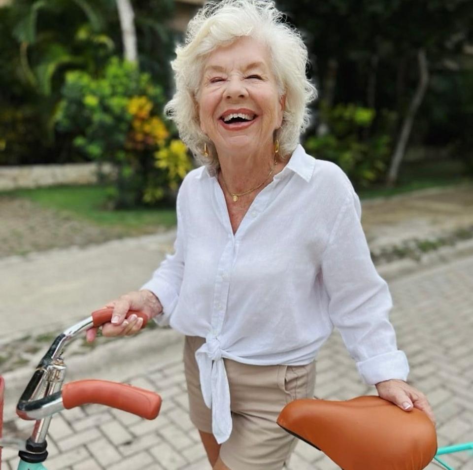 Joan smiling while holding a bicycle