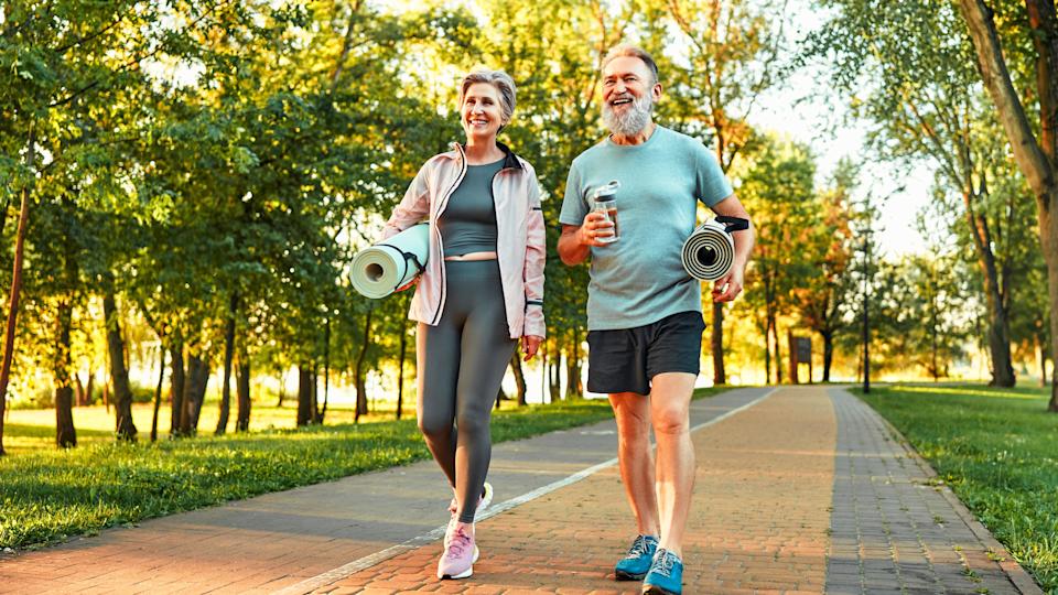 a senior couple carrying yoga mats