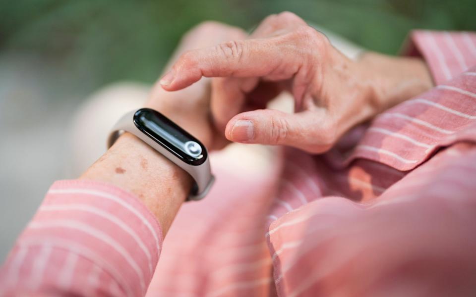 Senior woman using fitness tracker app on smart watch