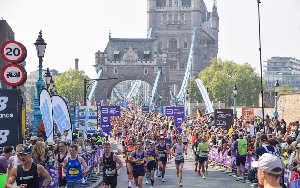 Runners pass across Tower Bridge during the London Marathon 2025