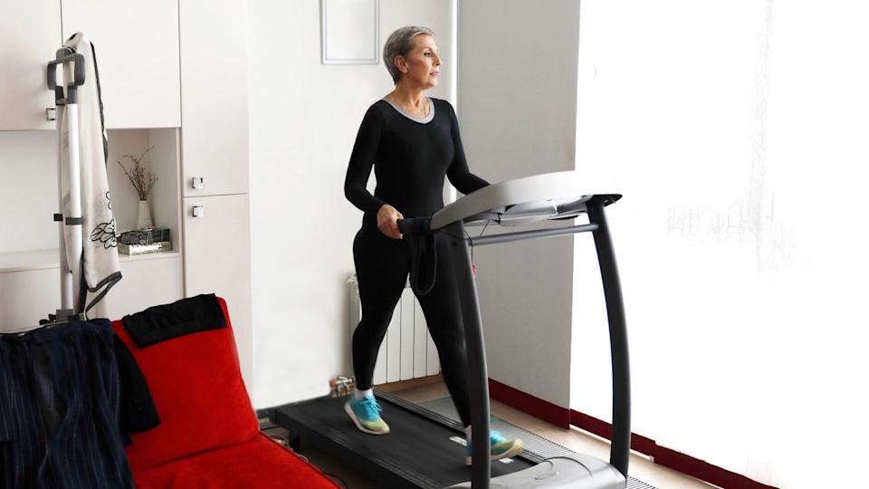 Woman walking on treadmill at home.