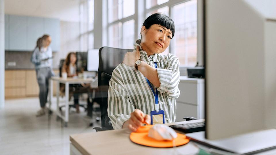 Businesswoman having neck ache due to work over load and bad posture.