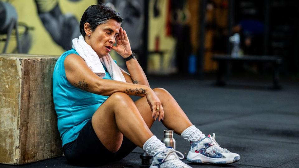  Senior woman sits on the floor in the gym to take a rest. 